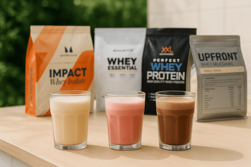 Goedkoopste eiwitpoeder: Impact Whey Protein van Myprotein, Whey Essential van Body & Fit, Perfect Whey Protein van XXL Nutrition en Whey Milkshake van Upfront op buitenaanrecht met drie glazen gevuld met eiwitshake - Test door Eiwitshakestore